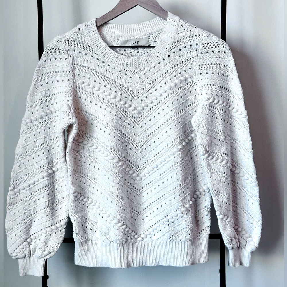 Cream sweater with cutout detail.